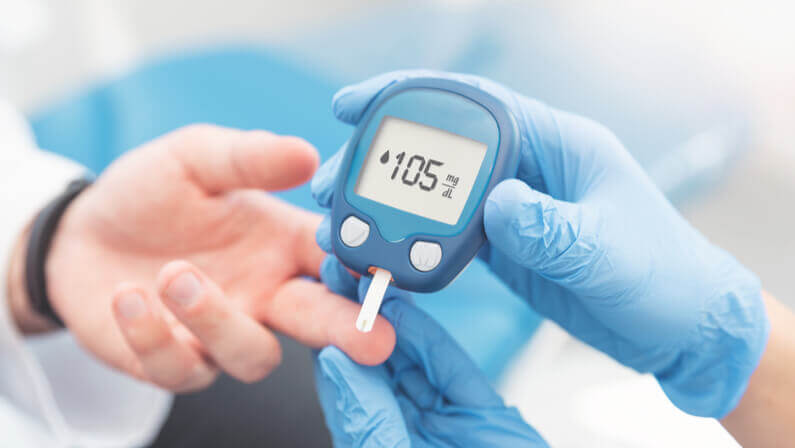 doctor checking blood sugar level with glucometer