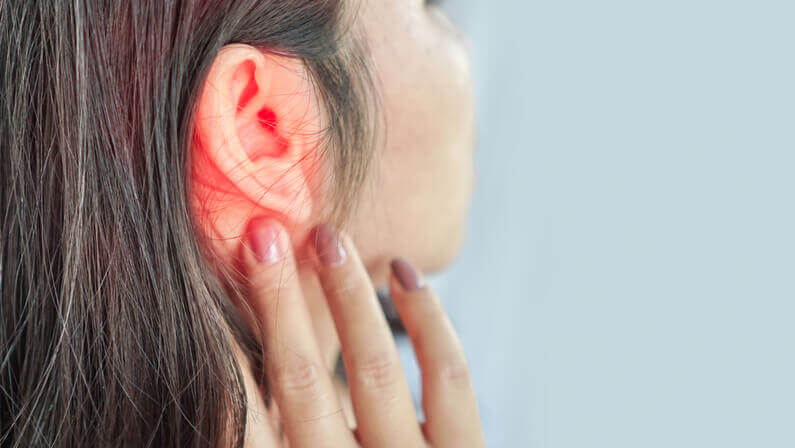 lady touching her infected ear