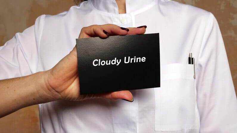 medical practitioner holder a black card with cloudy urine wording