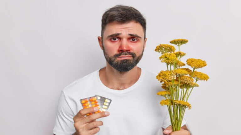 man holding flowers and medicine for hay fever