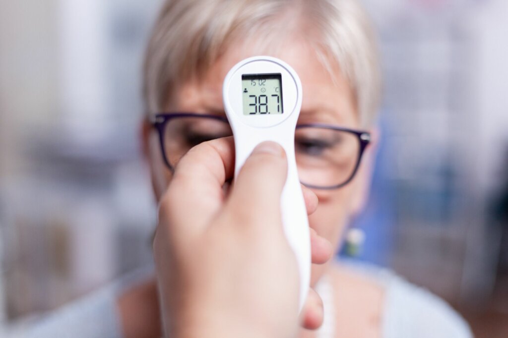 Examination of body temperature of senior woman in hospital room during examination test. Medical consultation for infections and disease during global pandemic,flu, tool, sickness.