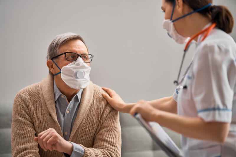 Doctor And Senior Man Wearing Facemasks During Coronavirus And Flu